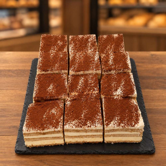 Nueve porciones de tiramisú artesanal sobre pizarra