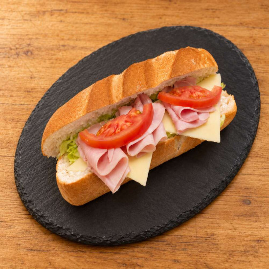 Bocadillo vegetal de jamón York y queso sobre pizarra