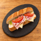 Bocadillo vegetal de jamón York y queso sobre pizarra